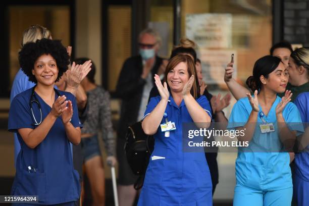 Workers participate in a national "clap for carers" to show thanks for the work of Britain's NHS workers and other frontline medical staff around the...