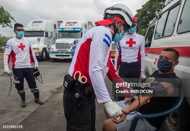 International Red Cross workers check truck drivers pressure and temperature during a blockade at Penas Blancas border between Nicaragua and Costa...