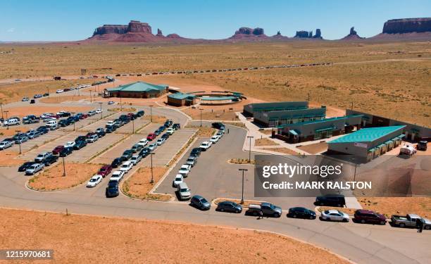 Navajo Indians line up in their vehicles to collect water and supplies from a distribution point, as the Covid-19 virus spreads through the Navajo...