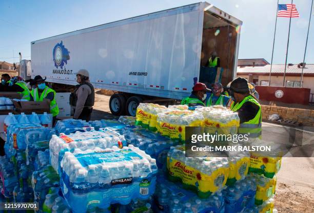Navajo Indians line up in their vehicles to collect water and supplies from a distribution point, as the Covid-19 virus spreads through the Navajo...