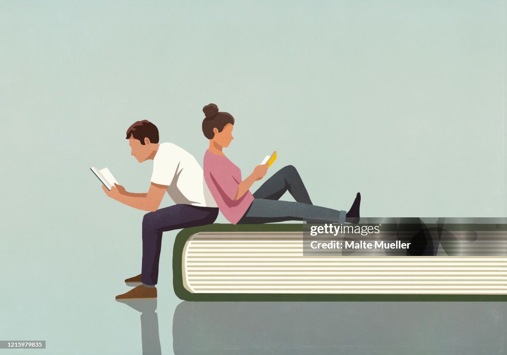 Couple reading books on large book