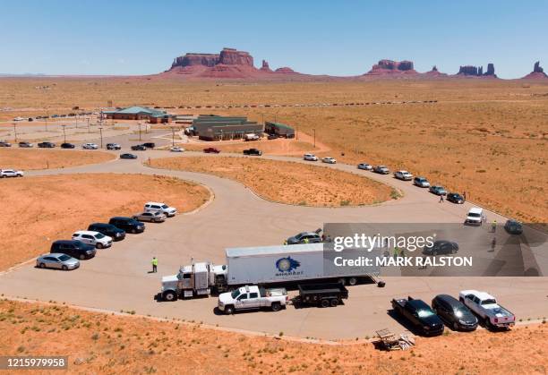 Navajo Indians line up in their vehicles to collect water and supplies from a distribution point, as the Covid-19 virus spreads through the Navajo...