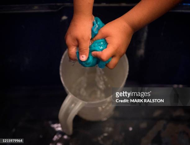 Gary Larson from a family with no running water in their home, washes his hands in the Navajo Nation town of Thoreau in New Mexico on May 22, 2020. -...