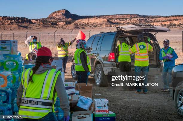 Navajo Indians line up in their vehicles to collect water and supplies from a distribution point, as the Covid-19 virus spreads through the Navajo...