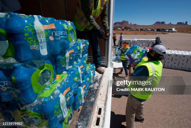 Navajo Indians line up in their vehicles to collect water and supplies from a distribution point, as the Covid-19 virus spreads through the Navajo...