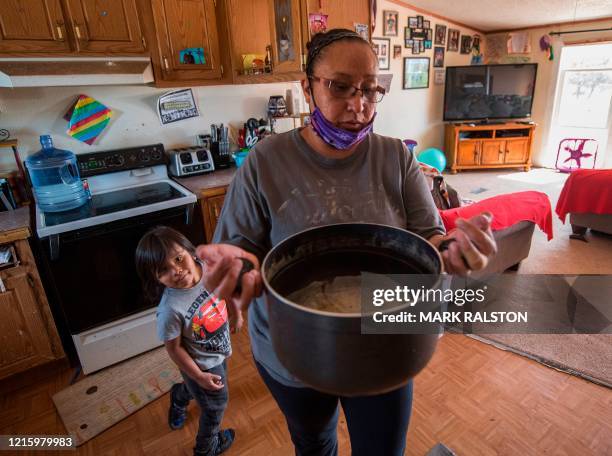 Amanda Larson who has no running water at her home, carries water for her son Gary Jr. To have a bath in the Covid-19 virus affected Navajo Nation...