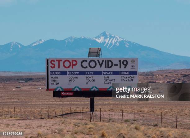 Sign warns against the Covid-19 virus near the Navajo Indian nation town of Tuba City, Arizona on May 24, 2020. - According to the Centers for...