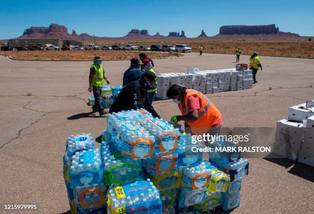 Navajo Indians line up in their vehicles to collect water and supplies from a distribution point, as the Covid-19 virus spreads through the Navajo...