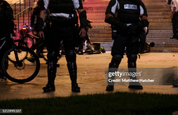 Columbus Ohio police officers stand guard while other officers arrest two men who they caught near the Ohio Statehouse following a protest which...