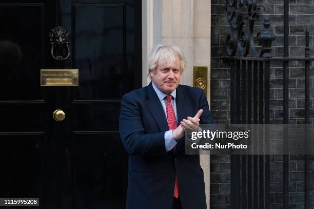 British Prime Minister Boris Johnson claps his hands outside 10 Downing Street during the weekly 'Clap for our Carers' applause for the NHS and key...