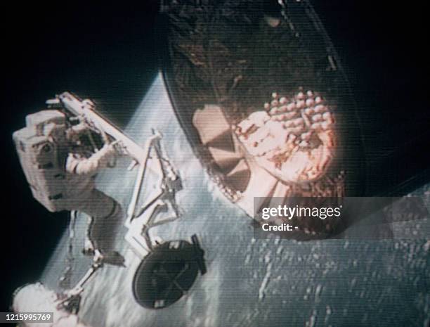 Astronaute américain Pierre Thuot rattaché à la navette spatiale américaine Endeavour par un cordon, flotte dans l'espace le 11 mai 1992 alors qu'il...