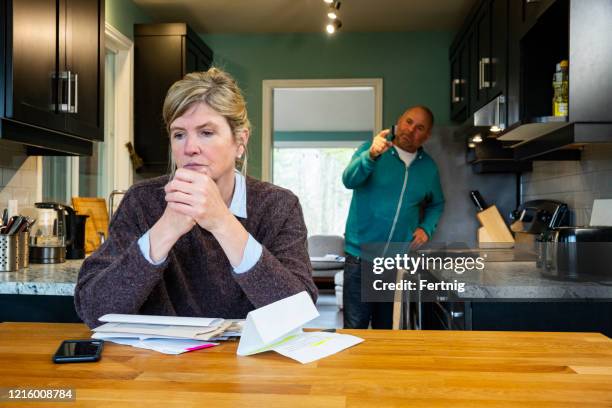 a man shouting at his female partner over home finances and debt. - partner violence stock pictures, royalty-free photos & images