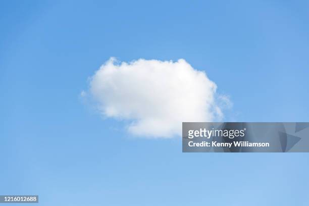 a single cumulus cloud in a blue sky - un singolo oggetto foto e immagini stock