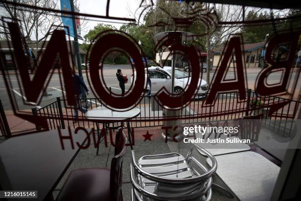 Bacon Restaurant co-owner Khaekai Lam carries a bag of groceries to a volunteer's car for delivery on March 31, 2020 in Novato, California. Tien Lam,...