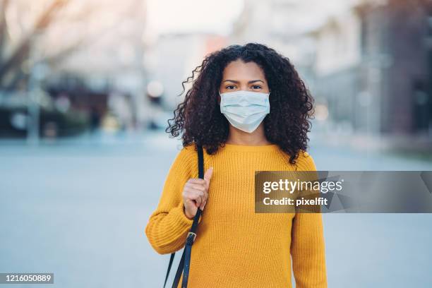 mujer joven con máscara durante la pandemia - máscara-protectora fotografías e imágenes de stock