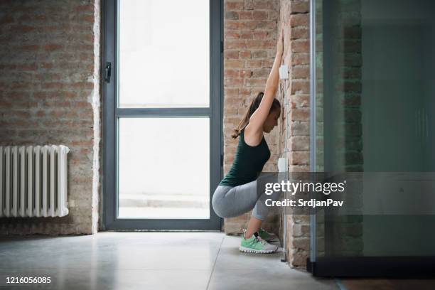 trick for strong legs - wall squat stock pictures, royalty-free photos & images