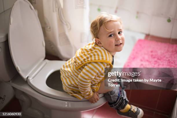 boy in the toilet smiling - plaspot stockfoto's en -beelden