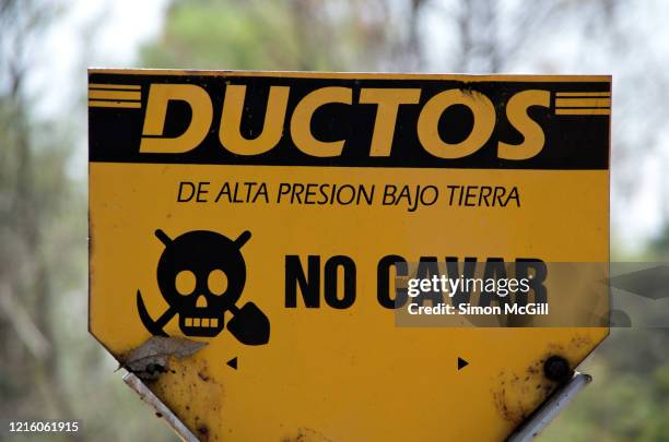 warning sign in spanish stating 'ductos de alta presion bajo tierra. no cavar (high pressure pipelines underground. do not dig.)' - pression stock pictures, royalty-free photos & images