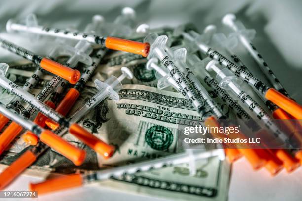 syringes covering two twenty dollar bills in heap - drug reform stock pictures, royalty-free photos & images