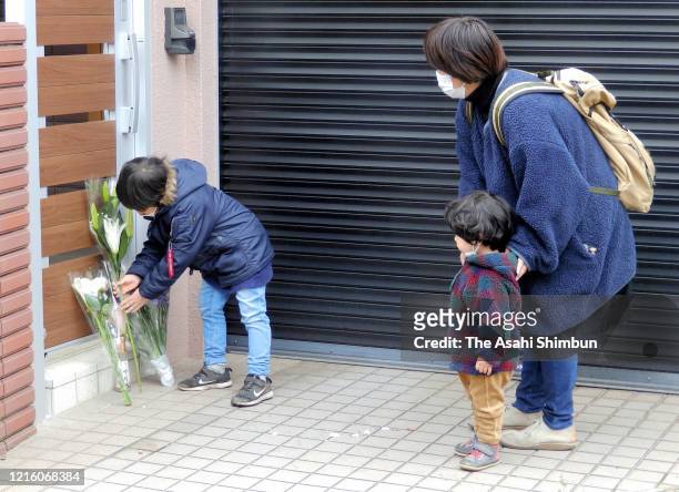 Boy offers a flower bouquet at home of late comedian Ken Shimura on March 30, 2020 in Mitaka, Tokyo, Japan. Popular comedian Shimura died of the...