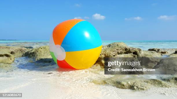 colorful beachball on the sandy tropical beach - close up shot - ゴムボール ストックフォトと画像