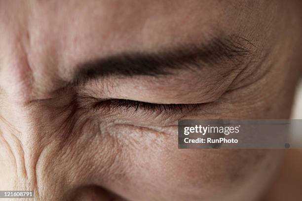 midleage woman,skin close-up - augen zukneifen stock-fotos und bilder