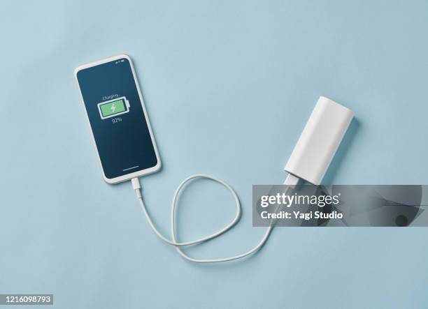 smart phone connected to portable charger - powerbank stock-fotos und bilder