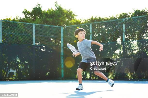 young boy with her older sister on a wheelchair playing tennis together on a tennis court - japanese tennis photos et images de collection