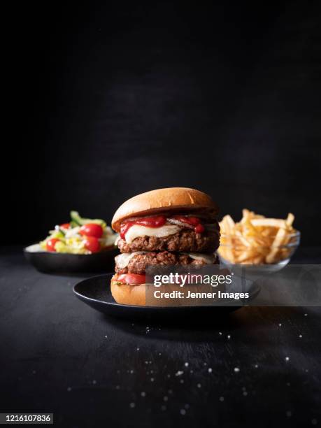 vegan double cheeseburger with chips and salad. - black plate stock pictures, royalty-free photos & images