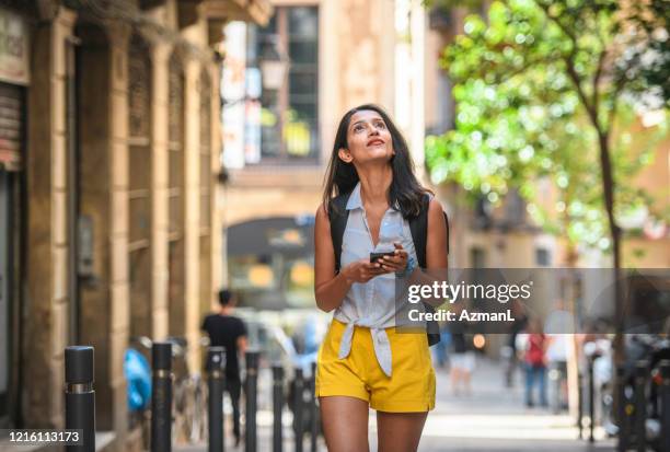 onafhankelijke vrouwelijke sightseer met slimme telefoon voor begeleiding - dichterbij komen stockfoto's en -beelden