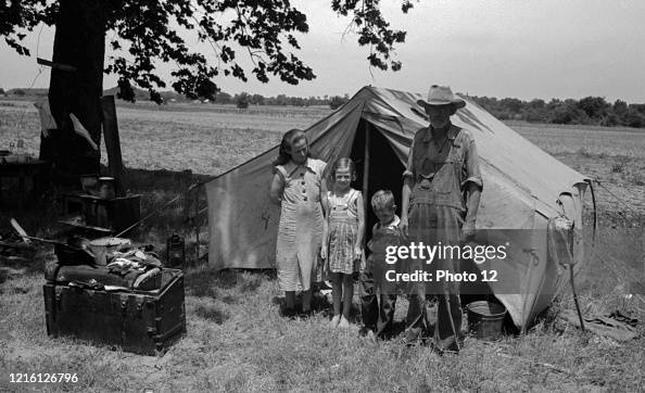 Veteran migrant agricultural worker and his family encamped on the Arkansas River.