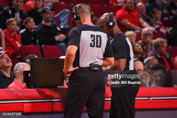 Referees John Noble and Dedric Taylor huddle up for a replay during the New Orleans Pelicans game against the Houston Rockets on October 26, 2019 at...