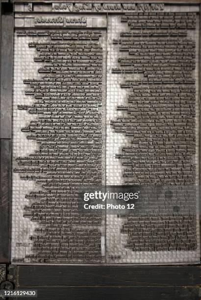 Metal plate with letters set to print a page from a reconstruction of a 16th Century printing press.
