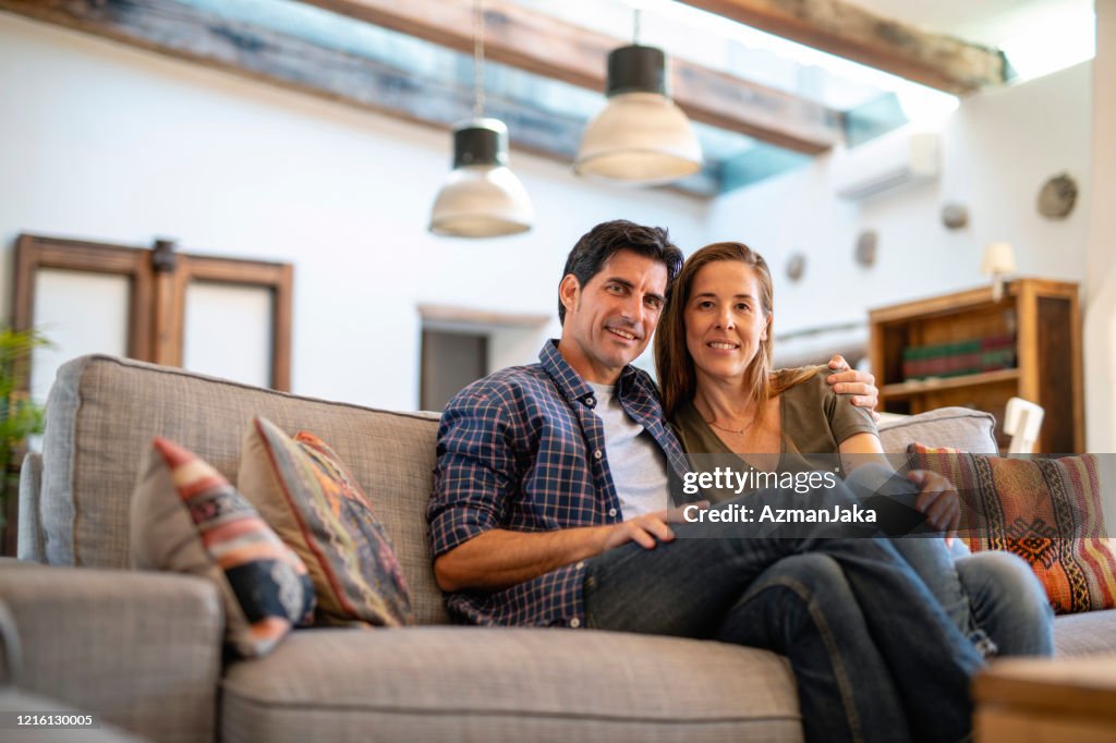 Relaxed Mature Couple Sitting Close on Sofa in Family Home