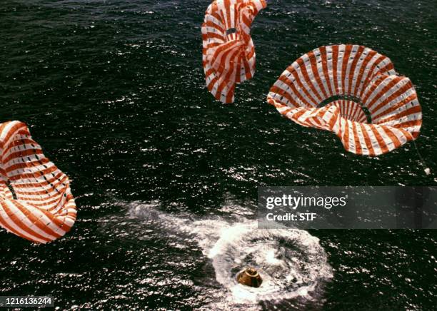 Photo de l'amerrissage de la capsule du vaisseau et des parachutes dans l'océan pacifique, . Les trois astronautes David R. Scott, Alfred M. Worden...