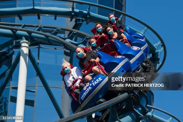 People wearing protective masks enjoy Euro-Mir roller coaster at Europa-Park, Germany's largest theme park, in Rust, on May 29, 2020 during the...