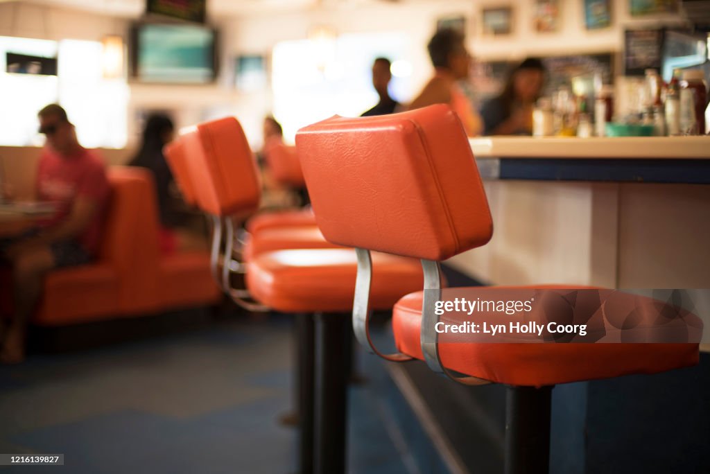 Red chairs and booth in defocussed diner
