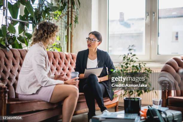 young businesswoman conversing in eclectic office space - business talk stock pictures, royalty-free photos & images
