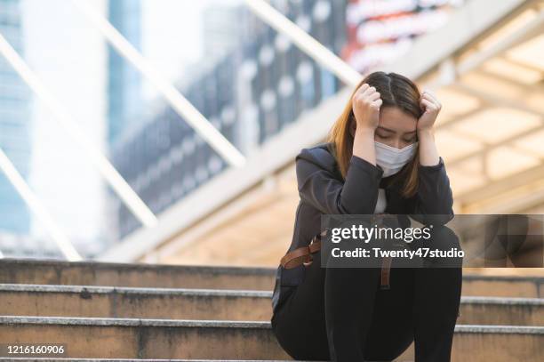 unemployed businesswoman depressed sitting on a path due to company bankrupted while coronavirus spreading situation - pandemia fotografías e imágenes de stock