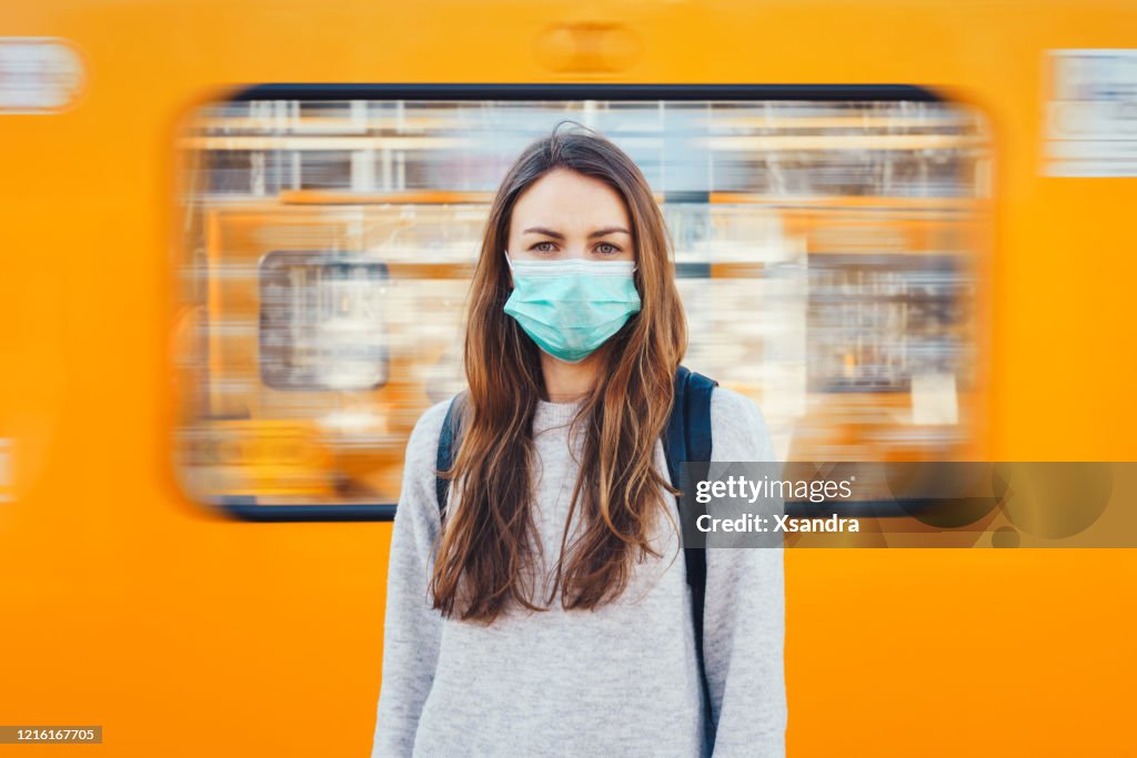 Frau trägt eine medizinische Maske in einer U-Bahn
