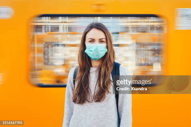 frau trägt eine medizinische maske in einer u-bahn - pandemic illness stock-fotos und bilder