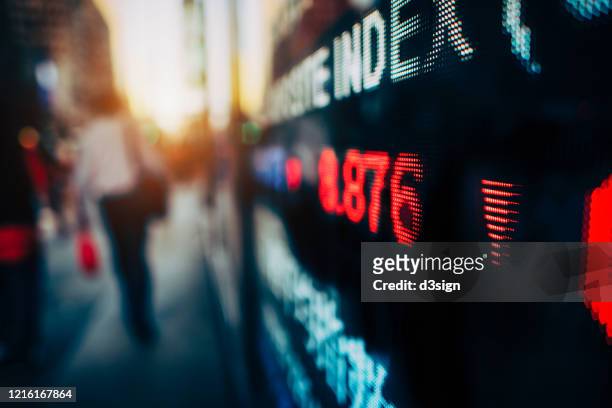 economic and financial impact during the covid-19 health crisis deepens. stock exchange market display screen board on the street showing stock market crash sell-off in red colour - financial fear stock pictures, royalty-free photos & images