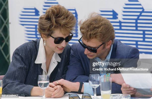 Le chanteur et acteur Johnny Hallyday et sa compagne l'actrice Nathalie Baye, au 37ème Festival de Cannes, sont venus présenter le film "Détective"...