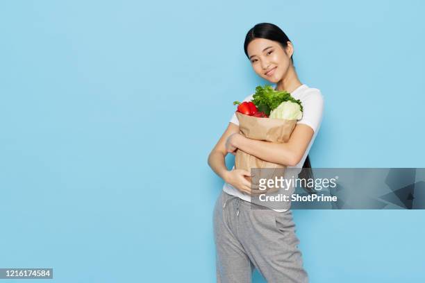young woman shopper in a supermarket bought vegetables and fruits fresh for a healthy lifestyle and proper nutrition. - national diet of japan stock pictures, royalty-free photos & images