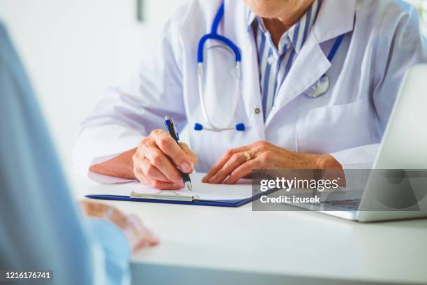 close up of senior female doctor's hands - gp visit stock pictures, royalty-free photos & images