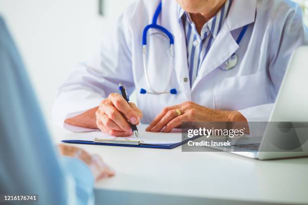 close up of senior female doctor's hands - office visit stock pictures, royalty-free photos & images