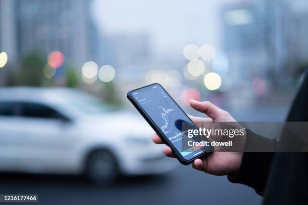 businesswoman reading financial trading data on smartphone - wuhan stock-fotos und bilder