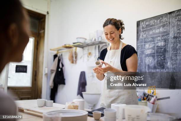 female pottery artists making porcelain pots in art studio - store studios ストックフォトと画像