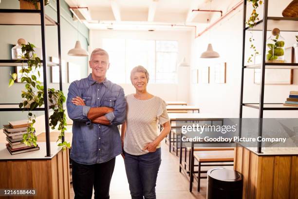 gammalt par leende medan de står tillsammans i sitt café - business mature couple portrait bildbanksfoton och bilder