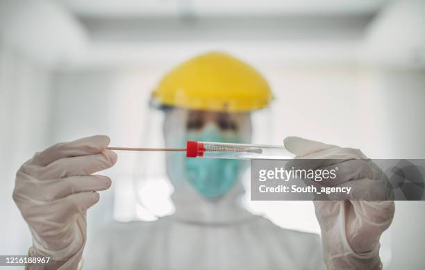 doctor showing covid-19 tube test and sampling swab - coronavirus stock pictures, royalty-free photos & images